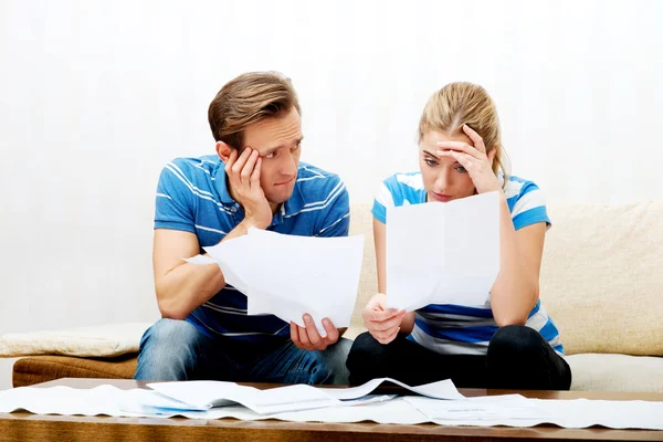 Casal preocupado depois de calcular contas sentado em casa — Fotografia de Stock