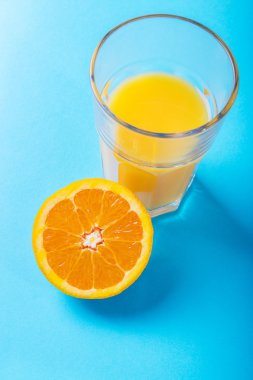 Bardak portakal suyu ve portakal yarısı
