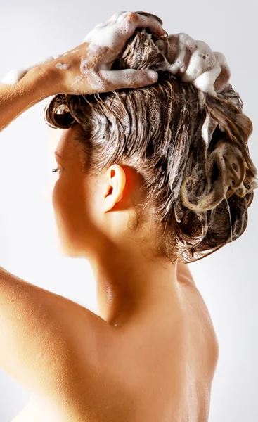 Kvinnan duschar och schamponerar håret. Isolerad på vitt. — Stockfoto
