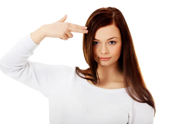 Young woman shoots herself in the head with finger gun gesture — Stock Photo, Image