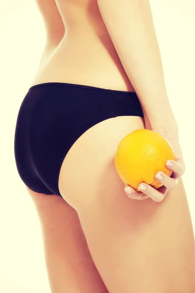 Belles fesses féminines avec orange . — Photo