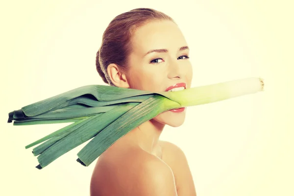 Mooie vrouw met verse groene prei in mond — Stockfoto