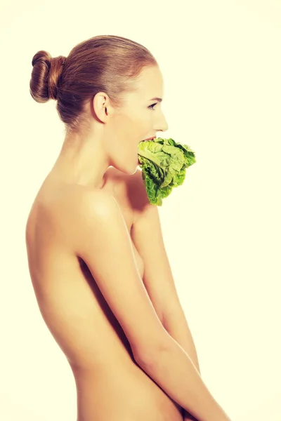 Schöne Frau mit frischem grünen Salat im Mund. — Stockfoto