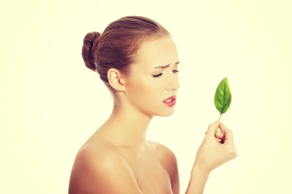 Hermosa mujer con una hoja verde . — Foto de Stock