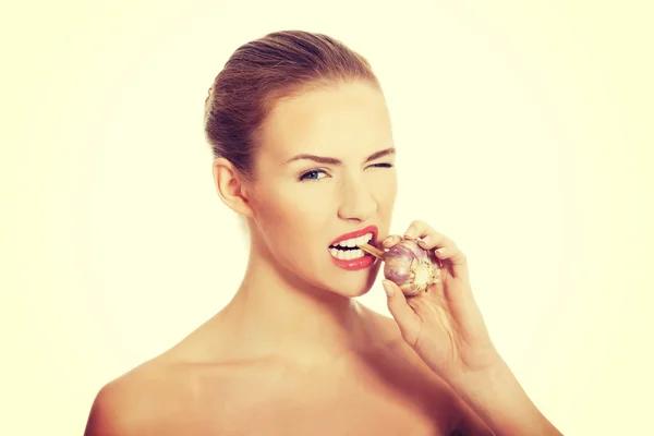 Beautiful woman with raw garlic in mouth. — Stock Photo, Image