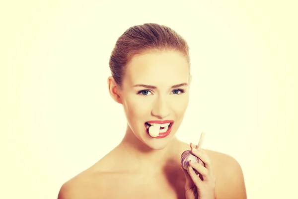 Schöne Frau mit rohem Knoblauch im Mund. — Stockfoto