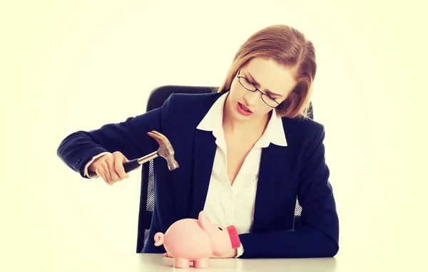 Geschäftsfrau versucht Sparschwein zu zerstören — Stockfoto
