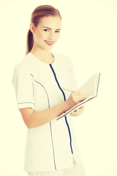 Enfermera o médico está escribiendo en un cuaderno . —  Fotos de Stock