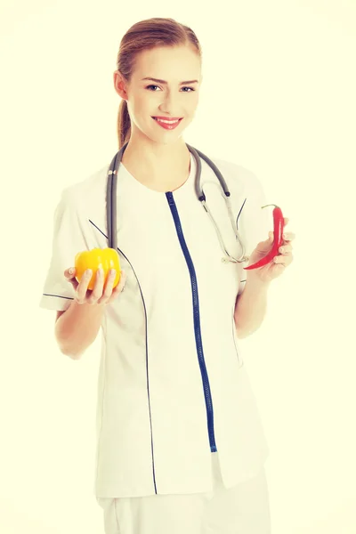 Médico o enfermera sostiene una naranja y chi —  Fotos de Stock