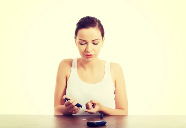 Mujer tomando prueba de nivel de azúcar — Foto de Stock