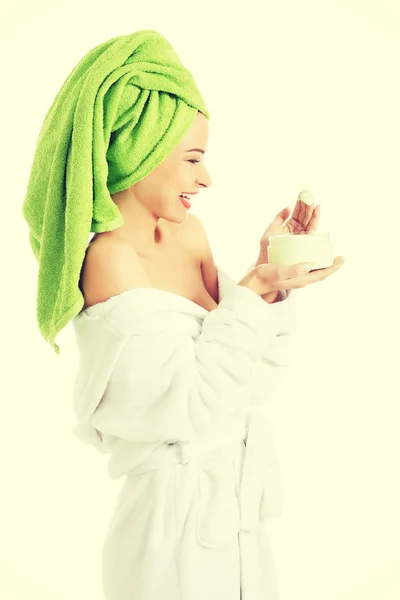 Woman in bathrobe with cream — Stock Photo, Image