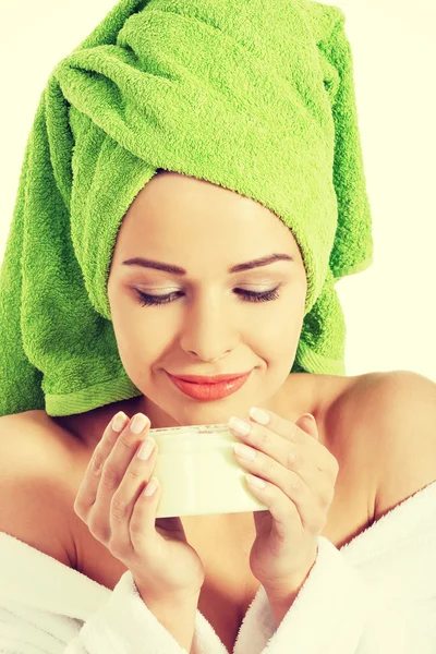 Woman in bathrobe with cream — Stock Photo, Image