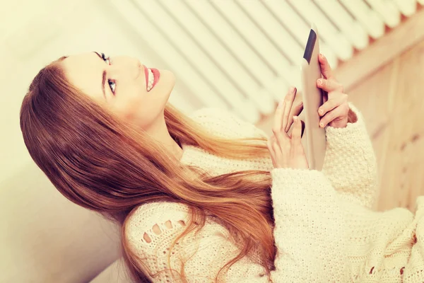 Mooie vrouw zittend op de vloer met tablet. — Stockfoto