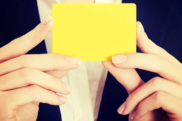 Cartão amarelo vazio em mãos femininas . — Fotografia de Stock