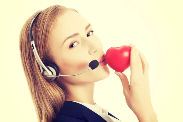 Young call center woman holding heart — Stock Photo, Image