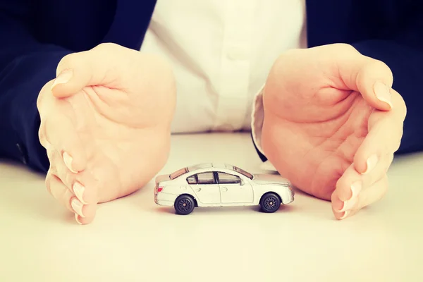 Close up on car toy model between hands. — Stock Photo, Image