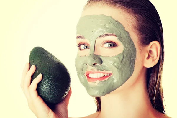 Spa vrouw in gezichtsmasker en avocado — Stockfoto