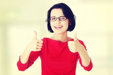 Woman in casual clothes gesturing thumbs up. clipart