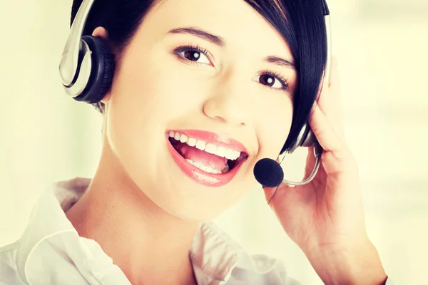 Jovem assistente de call center sorrindo para a câmera — Fotografia de Stock