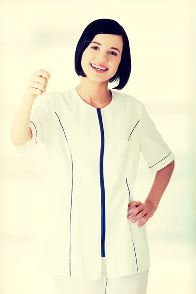 Woman doctor or nurse holding business card — Stock Photo, Image