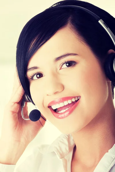 Hermosa joven asistente de centro de llamadas sonriendo — Foto de Stock