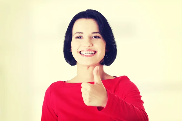 Schöne junge Frau gestikuliert Daumen hoch. — Stockfoto