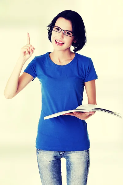 Studium der glücklichen jungen Frau beim Lesen ihres Notizbuchs — Stockfoto