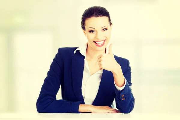 Mujer joven en el escritorio gesto OK — Foto de Stock