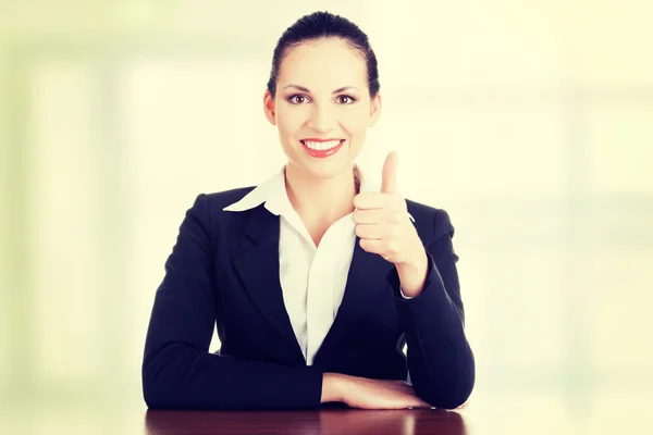 Young woman at the desk gesturing OK — Stock Photo, Image