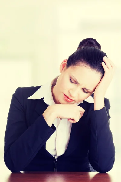 Traurige Geschäftsfrau sitzt hinter dem Schreibtisch — Stockfoto