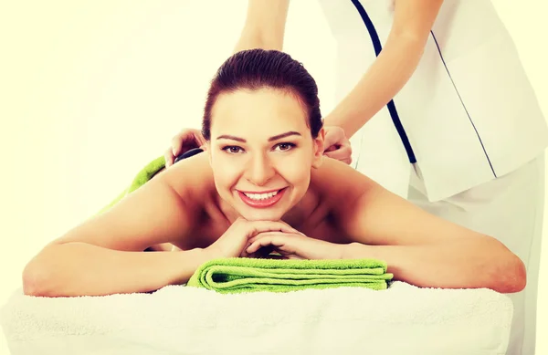 Bella donna sdraiata sul salone spa con massaggio in pietra . — Foto Stock
