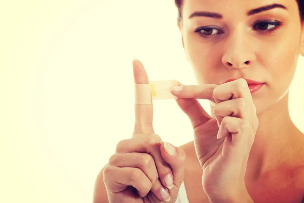 Beautiful woman with plaster on her finger. — Stock Photo, Image