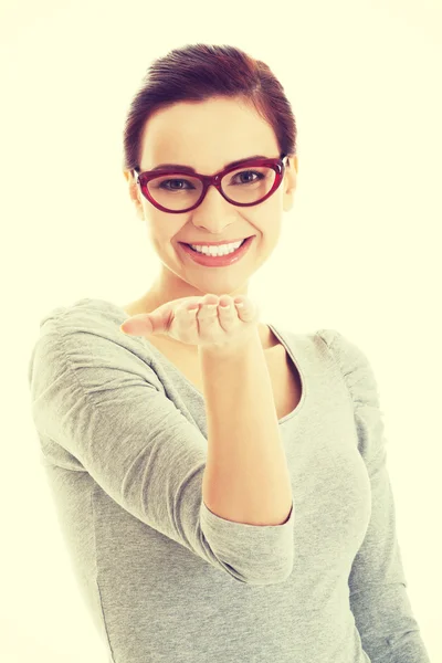 Young casual woman with open palm in front. — Stock Photo, Image