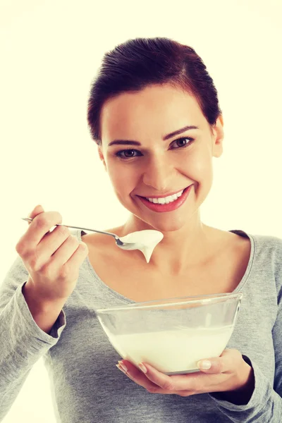 Casual jongedame eten een yoghurt. — Stockfoto