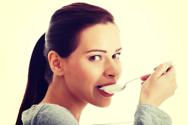 ヨーグルトを食べる若いカジュアルな女性. — ストック写真