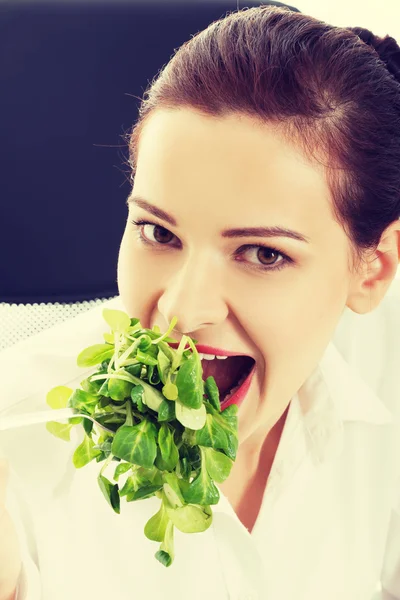 Schöne Geschäftsfrau sitzt und Salat isst. — Stockfoto