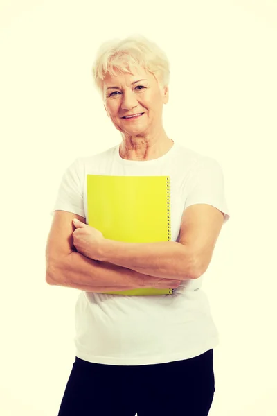 An old woman holding a workbook. — Stock Photo, Image