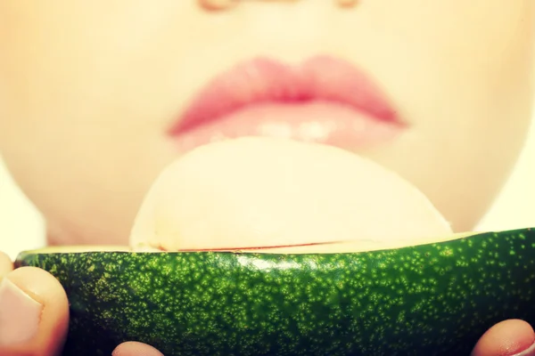 Close-up op avocado hel door een mooie vrouw. — Stockfoto