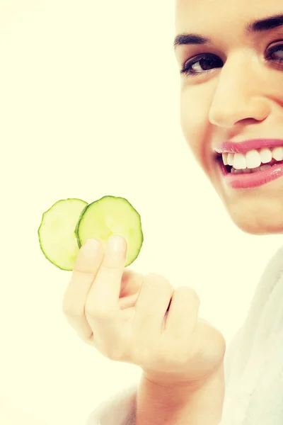 Mulher bonita em roupão segurando fatias de pepino . — Fotografia de Stock