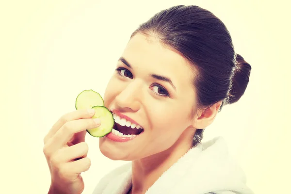 Beautiful woman in bathrobe holding slices of cucumber. — Stock Photo, Image