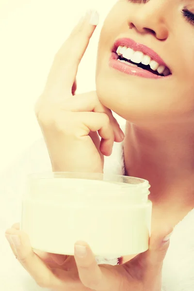 Beautiful woman applies face cream. — Stock Photo, Image