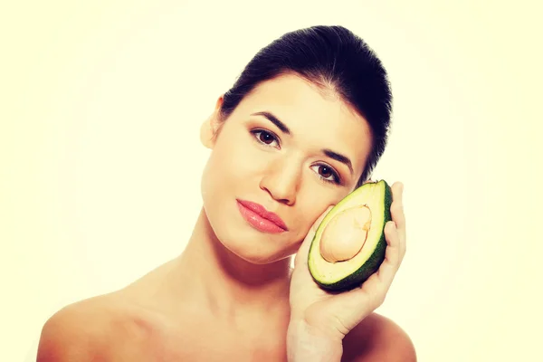 Beautiful womans face with avocado. — Stock Photo, Image