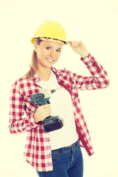 Mujer casual joven sosteniendo taladro y usando casco de seguridad . —  Fotos de Stock