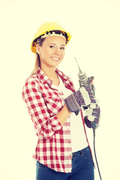 Mujer casual joven sosteniendo taladro y usando casco de seguridad . —  Fotos de Stock