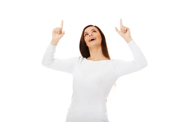 Smiling young woman shows something — Stock Photo, Image