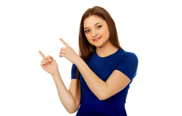 Mujer joven sonriente señalando hacia arriba. — Foto de Stock