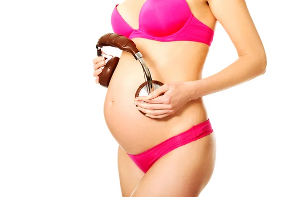 Pregnant woman with headphones on her belly — Stock Photo, Image