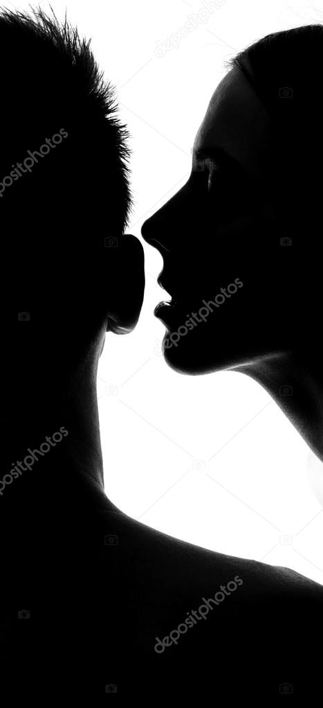 Woman whispering at ear in studio silhouette