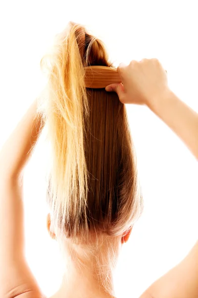 Menina com cabelos longos e lisos penteando-se. — Fotografia de Stock
