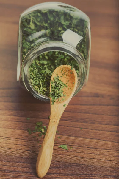 木のスプーンが付いているガラス瓶に乾燥パセリ — ストック写真